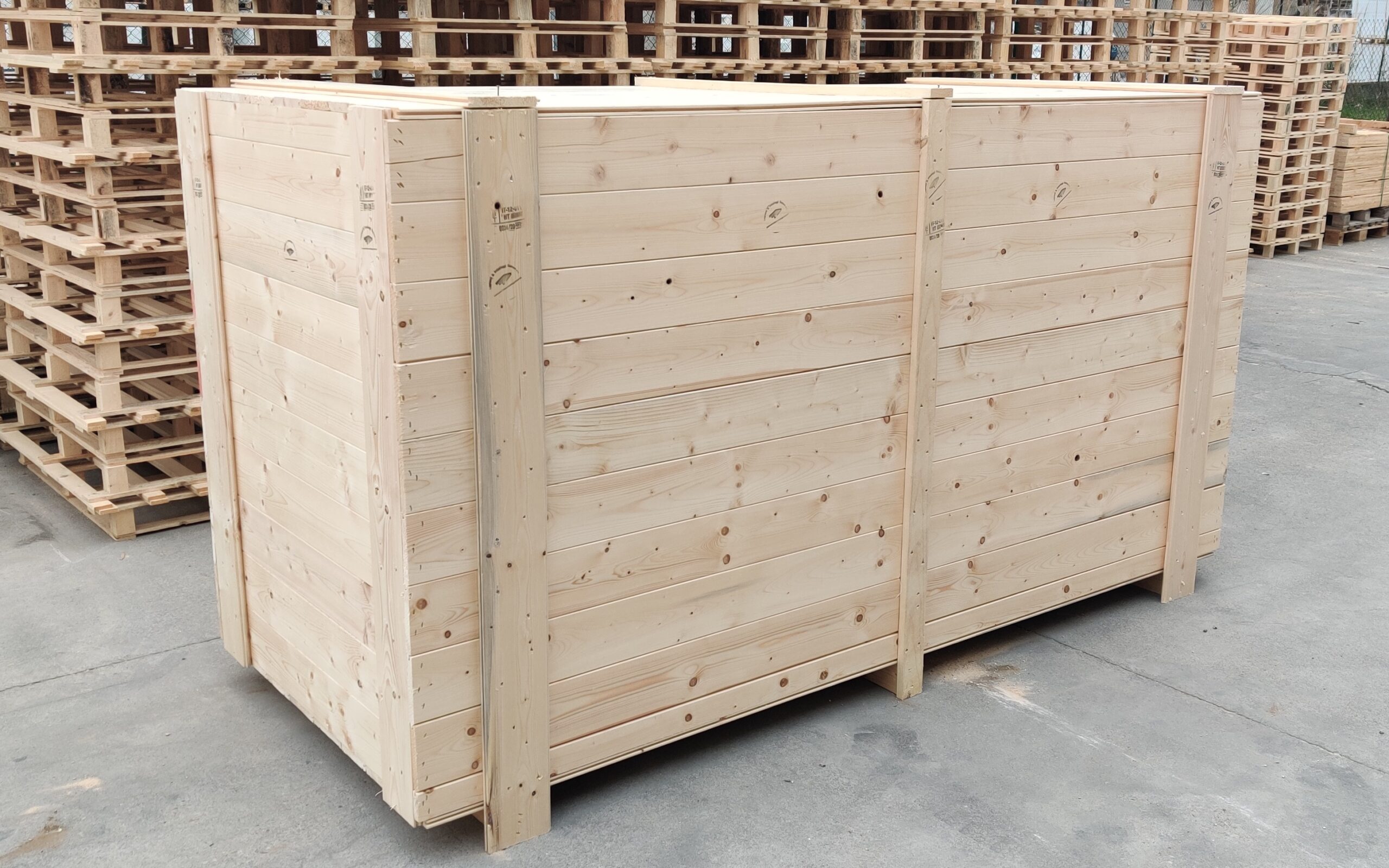 Cassa di legno su pavimento, circondata da pallet.